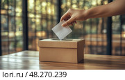 A voter is placing a ballot into a cardboard box, showcasing civic engagement in a bright, contemporary polling location during election time. Стоковое AI-изображение, AI-художник Данила Большаков / Фотобанк Лори
