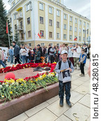 Мальчик фотографируется с фотографией своего прадедушки ветерана Великой Отечественной войны на фоне вечного огня в праздник победы 9 мая в городе Кирове в Александровском саду на набережной реки Вятки. Редакционное фото, фотограф Светлана Русских / Фотобанк Лори