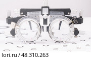 Close -up glasses of optometrist for supporting points and checking visual acuity on vision test table. concept. Стоковое фото, фотограф Скрипачев Антон / Фотобанк Лори