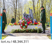 Ленинградская обл., Россия, 9 мая 2025 г.: Почётный воинский караул на Братской могиле советских воинов, погибших в борьбе с фашистами в годы Великой Отечественной войны у деревни Грузино. Скульптурная группа, отлитая в металле - солдаты, возлагающие венок в окружении венков и цветов. Редакционное фото, фотограф Сергей Комаров / Фотобанк Лори
