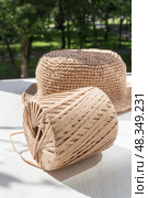 The process of knitting a raffia hat, a skein of yarn, a hook on a wooden background. Стоковое фото, фотограф Татьяна Васильева / Фотобанк Лори