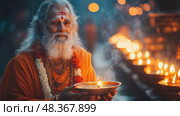 A spiritually attired man with a long beard holds an oil lamp, surrounded by glowing candles during a festive evening in India. Стоковое AI-изображение, AI-художник Данила Большаков / Фотобанк Лори