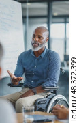Confident businessman in wheelchair leading a meeting. Стоковое AI-видео, аниматор Юрий Поздников / Фотобанк Лори