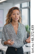 Young businesswoman speaking and gesturing in modern office. Стоковое AI-видео, аниматор Юрий Поздников / Фотобанк Лори