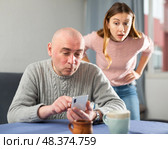 Man is texting on a mobile phone, while woman is outraged. Стоковое фото, фотограф Яков Филимонов / Фотобанк Лори