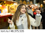 Portrait of dreamily happy girl with Christmas balls in her hands at a street fair in evening. Стоковое фото, фотограф Яков Филимонов / Фотобанк Лори