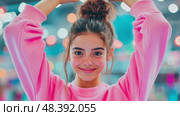 A girl in a pink sweater poses joyfully with arms raised in a vibrant indoor environment filled with colorful decorations and lights, showcasing a cheerful and energetic atmosphere. Стоковое AI-видео, аниматор Данила Большаков / Фотобанк Лори