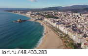 Picturesque aerial view of Blanes cityscape on Mediterranean coast overlooking symbol of city, Sa Palomera Rock and large sandy beach on sunny day, Catalonia, Spain. Стоковое видео, видеограф Яков Филимонов / Фотобанк Лори