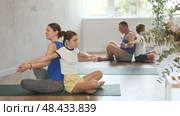 Happy mother and daughter practicing yoga poses in pairs with other family members. Стоковое видео, видеограф Яков Филимонов / Фотобанк Лори