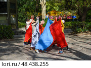 Shanghai, China - 1 April 2025: Senior Chinese women perform a colorful folk dance in People’s Park, gracefully moving in coordinated steps. Редакционное фото, фотограф Татьяна Терехина / Фотобанк Лори