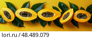 Summer fruits papaya halves with vibrant orange flesh and black seeds, surrounded by green foliage on a yellow surface. Стоковое AI-изображение, AI-художник Данила Большаков / Фотобанк Лори