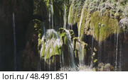 Pristine waterfall tumbling over moss-covered stones, sunlight piercing misty veil, revealing verdant turkish landscape's enchanting natural splendor. Стоковое видео, видеограф ILIA GOROKHOV / Фотобанк Лори
