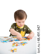 Little boy playing puzzle on a white background. Стоковое фото, фотограф Юлия Бабкина / Фотобанк Лори