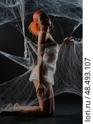 Red-haired woman caught in a delicate web of nets in a dark studio. Стоковое фото, фотограф Гурьянов Андрей / Фотобанк Лори