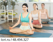 Young girl sitting in Padmasana with hands in mudra at yoga class. Стоковое фото, фотограф Яков Филимонов / Фотобанк Лори