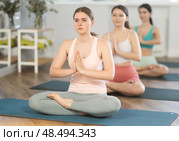 Young girl sitting in lotus pose with hands in prayer gesture. Стоковое фото, фотограф Яков Филимонов / Фотобанк Лори