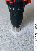 Rotating diamond core holesaw in hand power drill drills stone slab. Стоковое фото, фотограф Евгений Харитонов / Фотобанк Лори