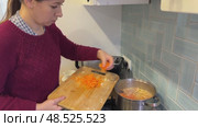 A pretty Caucasian woman is grating carrots for soup. Стоковое видео, видеограф Ирина Старикова / Фотобанк Лори