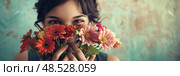 Charming woman standing and holding a bunch of colorful flowers in front of her face. Стоковое AI-изображение, AI-художник Данила Большаков / Фотобанк Лори