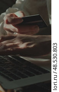 Vertical video. Female hands enter payment card data using laptop. Стоковое видео, видеограф Маргарита Кирьякова / Фотобанк Лори