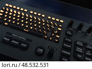 Marine navigation simulator. Close-up of an advanced control panel with glowing keyboard and function buttons, illuminated by orange lights. Стоковое фото, фотограф EugeneSergeev / Фотобанк Лори