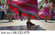 A close-up of a dancer's feet in traditional Mexican huaraches, mid-step during a folkloric dance performance. The vibrant skirt waving on air. Стоковое AI-видео, аниматор Sergey Grishin / Фотобанк Лори
