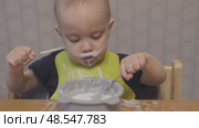funny baby toddler learning to eat with spoon, child learn eating use teaspoon. Стоковое видео, видеограф Olesia Kondrateva / Фотобанк Лори