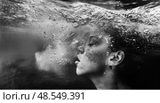 A woman holding her breath as she submerges her head underwater. Стоковое AI-изображение, AI-художник Данила Большаков / Фотобанк Лори