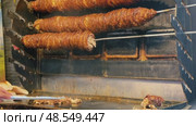 Street food vendor slicing and grilling traditional Turkish kokorec at a local food stall. Стоковое видео, видеограф Дмитрий Наумов / Фотобанк Лори