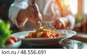 A skilled chef adds the finishing touch of herbs to a pasta dish in a warm, sunlit professional kitchen, showcasing culinary artistry. Стоковое AI-изображение, AI-художник Данила Большаков / Фотобанк Лори