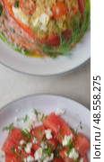 Fresh watermelon salad combining crumbled feta, chopped chives alongside bulgur stuffed bell peppers featuring tomatoes, dill, complemented by pine nuts, cranberry garnish. Стоковое видео, видеограф Данил Руденко / Фотобанк Лори