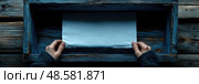 Hands carefully grasp a blank sheet of paper in a rustic blue wooden box placed on a textured wooden table, inviting thoughts and ideas. Стоковое AI-изображение, AI-художник Данила Большаков / Фотобанк Лори