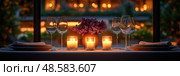 A beautifully arranged table awaits diners, featuring candles, flowers, and elegant glassware in a softly lit restaurant atmosphere. Стоковое AI-изображение, AI-художник Данила Большаков / Фотобанк Лори
