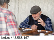 Пенсионеры с азартом играют в нарды. Активное долголетие. Редакционное фото, фотограф Evgenia Shevardina / Фотобанк Лори