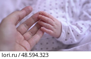Slow motion video of a mother taking her newborn baby by the hand. Стоковое видео, видеограф Darya Komarova / Фотобанк Лори
