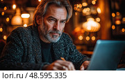 A man focuses intently on his laptop, surrounded by ambient lighting and a warm atmosphere in a bustling evening cafe. Стоковое AI-изображение, AI-художник Данила Большаков / Фотобанк Лори