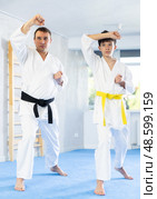 Teen boy and middle-aged man wearing kimono training karate techniques. Стоковое фото, фотограф Яков Филимонов / Фотобанк Лори