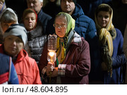 Belarus, Gomel, 8 April 2018. The Nikolsky Monastery. The celebration of Orthodox Easter. Grandmother with a candle in the church. Редакционное фото, фотограф Лазаренко Светлана / Фотобанк Лори