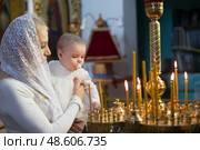 Belarus, Gomel, 25 March. 2018. The Prudhkovsky Church.The mother holds the child on her hands during the rite of baptism.Accept religion. Редакционное фото, фотограф Лазаренко Светлана / Фотобанк Лори