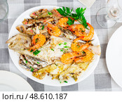 Deep-fried fish carcasses are served on plate - assorted Atlantic sea fish and shrimp. Стоковое фото, фотограф Яков Филимонов / Фотобанк Лори