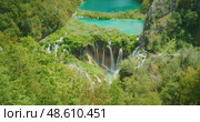 Scenic view of waterfalls cascading into turquoise lakes at Plitvice Lakes National Park Croatia summer. Стоковое видео, видеограф Ольга Сухарева / Фотобанк Лори