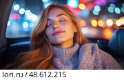 A woman with long hair smiles contentedly while resting in a moving car, surrounded by vibrant city lights at night. Стоковое AI-изображение, AI-художник Данила Большаков / Фотобанк Лори