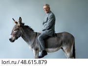 Businessman sits astride a donkey. Стоковое AI-изображение, AI-художник Дмитрий Киселёв / Фотобанк Лори