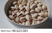 Delicious pistachios cascading into a bowl: nutty snack delight. Стоковое AI-видео, аниматор Башкирова Анна / Фотобанк Лори