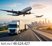 A large white airplane is flying over a city with a large truck on the ground. Стоковое AI-изображение, AI-художник Ярославский Максим / Фотобанк Лори