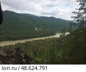 River flowing through a lush green valley with hills in the background under a cloudy sky. Стоковое фото, фотограф Александра Рублева / Фотобанк Лори