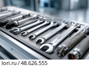 Variety of hand tools and accessories arranged on a workbench surface. Разнообразные ручные инструменты и принадлежности, разложенные на поверхности верстака. Стоковое AI-изображение, AI-художник Katsiaryna Repich / Фотобанк Лори