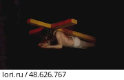 Jesus Christ with a cross on his back crawls bringing light into the darkness. Стоковое AI-видео, аниматор Андрей Митин / Фотобанк Лори