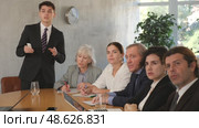 Young successful businessman tells his colleagues the presentation and future plans of the company. Стоковое видео, видеограф Яков Филимонов / Фотобанк Лори