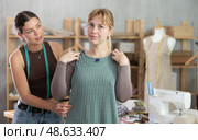 Female client and dressmaker checking tailored gown fit in studio. Стоковое фото, фотограф Яков Филимонов / Фотобанк Лори